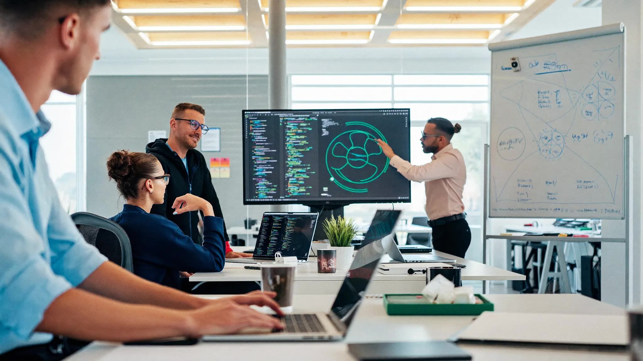 An AI engineering team reviewing model architecture on a monitor