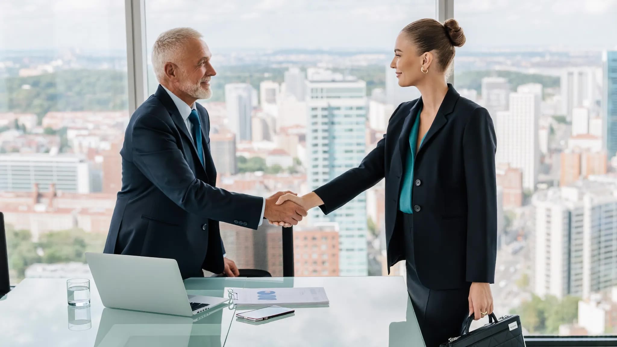 Two executives shaking hands in a boardroom